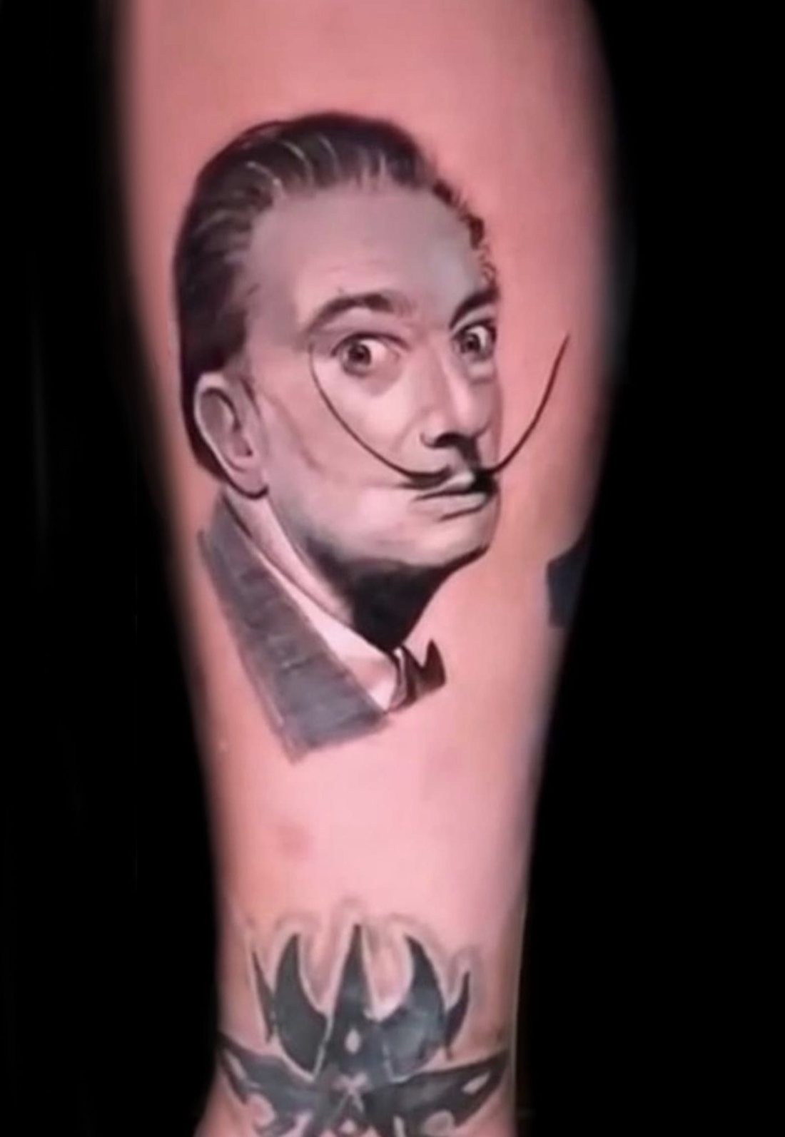 Retrato de Salvador Dalí tatuado en el brazo